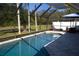 Screened-in pool area with clear water, lounge chairs, and outdoor dining set at 8731 Boysenberry Dr, Tampa, FL 33635