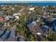 Aerial view of a quaint neighborhood with lush greenery and diverse architectural styles, near a blue ocean bay at 939 Mandalay Ave, Clearwater Beach, FL 33767