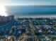 Overhead perspective reveals a coastal community with both residential houses and condominiums near a wide sandy beach and ocean at 939 Mandalay Ave, Clearwater Beach, FL 33767