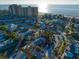 Coastal neighborhood aerial view featuring tree-lined streets, a nearby beachfront, and low-rise buildings at 939 Mandalay Ave, Clearwater Beach, FL 33767