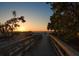 Scenic wooden walkway leading to a sandy beach with a sunset on the horizon at 939 Mandalay Ave, Clearwater Beach, FL 33767