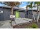 Exterior view of a home featuring a green front door, modern railings, and mature landscaping at 939 Mandalay Ave, Clearwater Beach, FL 33767