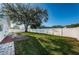 Large backyard with a brick patio, well-kept lawn, and a secure white fence at 9940 69Th N St, Pinellas Park, FL 33782