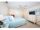 Bright bedroom featuring a ceiling fan, neutral carpet, and an inviting light blue quilt on the bed at 9940 69Th N St, Pinellas Park, FL 33782