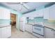 Bright kitchen connects to dining area, featuring white appliances and tile floor at 9940 69Th N St, Pinellas Park, FL 33782