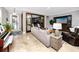 Spacious living room featuring travertine flooring, a stylish sofa, and view to a home office at 11311 Ravinia Park Blvd, Tampa, FL 33625