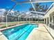 Sparkling pool within a screened enclosure, offering a private oasis for relaxation and recreation at 11420 Amboy St, Spring Hill, FL 34609