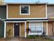 Charming two-story townhome with a covered porch, inviting entrance, and well-maintained landscaping at 13915 Village View Dr, Tampa, FL 33624