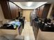 Galley style kitchen featuring dark cabinetry, stainless steel refrigerator, and tile flooring at 13915 Village View Dr, Tampa, FL 33624