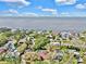 Scenic aerial view of a waterfront community featuring beautiful homes, lush trees, and tranquil ocean expanse at 140 Sage Cir, Crystal Beach, FL 34681