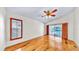 Bright bedroom featuring hardwood floors, shuttered windows, and sliding glass doors to the pool area at 140 Sage Cir, Crystal Beach, FL 34681