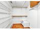 Spacious closet with wire shelving and wooden dowels, plus a bolted-down safe on the hardwood floor at 140 Sage Cir, Crystal Beach, FL 34681
