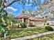 Charming single-story home with a well-manicured lawn, mature landscaping, and an attached two-car garage at 140 Sage Cir, Crystal Beach, FL 34681