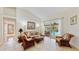 Cozy living room with vaulted ceiling, rattan furniture, and sliding doors leading to the screened pool area at 140 Sage Cir, Crystal Beach, FL 34681