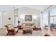 Comfortable living room featuring vaulted ceiling, neutral tile flooring and wicker furniture with patio access at 140 Sage Cir, Crystal Beach, FL 34681