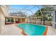 Backyard with a large screened-in pool, covered patio and outdoor seating area at 140 Sage Cir, Crystal Beach, FL 34681