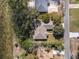 Aerial view of a cozy home surrounded by lush greenery and a quiet street, taken from directly above at 1472 Ivydale Rd, Spring Hill, FL 34606