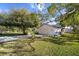 Inviting front yard view of a home with lush green lawn, shade trees, and a driveway leading to the garage at 1472 Ivydale Rd, Spring Hill, FL 34606