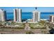 Aerial view of beachfront condos with manicured landscaping and tennis courts at 1520 Gulf Blvd # Ph1 1901, Clearwater Beach, FL 33767