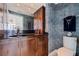 Elegant powder room with dark granite countertop, wood cabinets, decorative wall texture, and modern fixtures at 1520 Gulf Blvd # Ph1 1901, Clearwater Beach, FL 33767