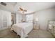 This bedroom is well-lit with two lamps, a ceiling fan, a mirror, and a door to the bathroom at 1718 Evans Dr, Clearwater, FL 33759