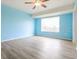 Bright bedroom with light blue walls, ceiling fan, and a large window at 18663 Kerrville Cir, Port Charlotte, FL 33948