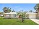 Charming single-story home featuring a well-manicured lawn and tropical landscaping at 18663 Kerrville Cir, Port Charlotte, FL 33948
