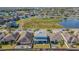 Aerial view of a home with a green lawn and a community pond at 2111 Roanoke Springs Dr, Ruskin, FL 33570