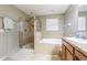 Bathroom featuring a glass-enclosed shower, soaking tub, and dual vanities at 2111 Roanoke Springs Dr, Ruskin, FL 33570