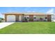 Charming single-story home featuring a well-maintained lawn, brick accents, and an attached garage at 28 Caddy Rd, Rotonda West, FL 33947