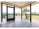 Enclosed patio with tile flooring offering a view of the green backyard and surrounding landscape at 28 Caddy Rd, Rotonda West, FL 33947