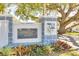 Community entrance sign for Douglas Arms, a 55+ community, is framed by lush greenery and mature trees at 300 Glennes Ln # 203, Dunedin, FL 34698
