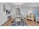 Charming dining area featuring a round table with seating, elegant lighting, and a glimpse of the living space at 300 Glennes Ln # 203, Dunedin, FL 34698