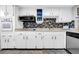 Functional kitchen showcasing white cabinetry, tile backsplash, and modern appliances at 300 Glennes Ln # 203, Dunedin, FL 34698