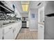 Bright kitchen features white cabinets, mosaic backsplash, wood-look floors and updated appliances at 300 Glennes Ln # 203, Dunedin, FL 34698