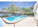 Outdoor pool with brick pavers, palm trees, and plenty of lounge chairs at 300 Glennes Ln # 203, Dunedin, FL 34698