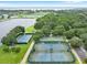 Aerial view of tennis and basketball courts, offering recreational opportunities with water in the background at 306 Oakwood Blvd, Oldsmar, FL 34677