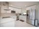 The all-white kitchen has stainless steel appliances, quartz countertops and marble tile floors at 4415 4Th S Ave, St Petersburg, FL 33711