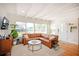 Bright and airy living room with a comfortable leather sofa, large windows, and hardwood floors at 4415 4Th S Ave, St Petersburg, FL 33711