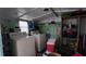 Inside view of a laundry room with a washer, dryer, storage shelves, and green paneled walls at 4641 Orange Blossom Dr, Zephyrhills, FL 33542