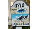 A whimsical address sign reading 4710 'Aloha Life's a Beach' with beach chairs and a blue umbrella painted on the wooden sign at 4710 22Nd N Ave, St Petersburg, FL 33713
