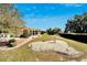 Large backyard with a covered patio, mature landscaping and green lawns, perfect for outdoor living at 612 Allegheny Dr, Sun City Center, FL 33573