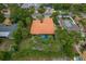 Aerial view of a property showcasing an orange tile roof, a screened pool and mature landscaping at 710 Treasure Boat Way, Sarasota, FL 34242