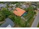 Aerial view of a property showcasing an orange tile roof, a screened pool and mature landscaping at 710 Treasure Boat Way, Sarasota, FL 34242