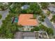 Aerial view of a property showcasing an orange tile roof, mature landscaping, patio and well-maintained grounds at 710 Treasure Boat Way, Sarasota, FL 34242