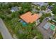Aerial view of a property showcasing an orange tile roof, a screened pool, landscaping and well-maintained grounds at 710 Treasure Boat Way, Sarasota, FL 34242