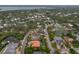 Aerial view of a neighborhood and waterway featuring a home with an orange tile roof and screened-in pool at 710 Treasure Boat Way, Sarasota, FL 34242
