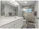 Bathroom featuring a walk-in shower with glass doors, a white vanity, and light wood-look flooring at 710 Treasure Boat Way, Sarasota, FL 34242