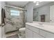 Modern bathroom featuring a tiled walk-in shower with glass doors, white vanity, and silver fixtures at 710 Treasure Boat Way, Sarasota, FL 34242