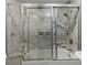 Bathroom featuring a shower/tub combination with glass doors and marble style walls at 710 Treasure Boat Way, Sarasota, FL 34242